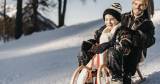 Vater und Sohn rodeln im Winterwonderland in Salzburg Land.