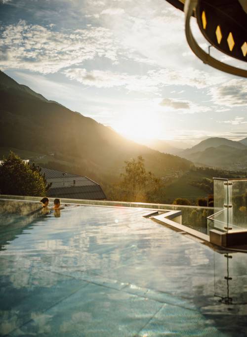 Der Ausblick auf die Berglandschaft vom Infinity-Rooftop Pool im Winter.