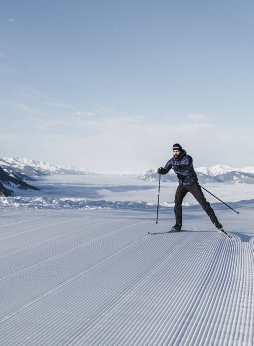 Ein älteres Paar genießt die Zeit beim Langlaufski in Salzburg. 