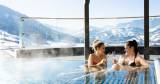 Im Sporhotel Alpina genießen zwei Frau einen Sekt im gepflegten Spa-Außenbereich. 