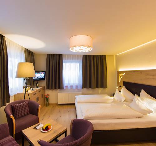 Das Doppelzimmer in Salzburg besitzt eine Lampe, ein Bett und eine gemütliche Sitzecke, die zum Verweilen einlädt. 