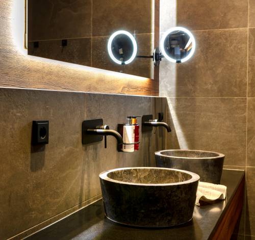 Das Badezimmer in unserem Familienzimmer in Salzburg besitzt ein Ringlicht-Spiegel.