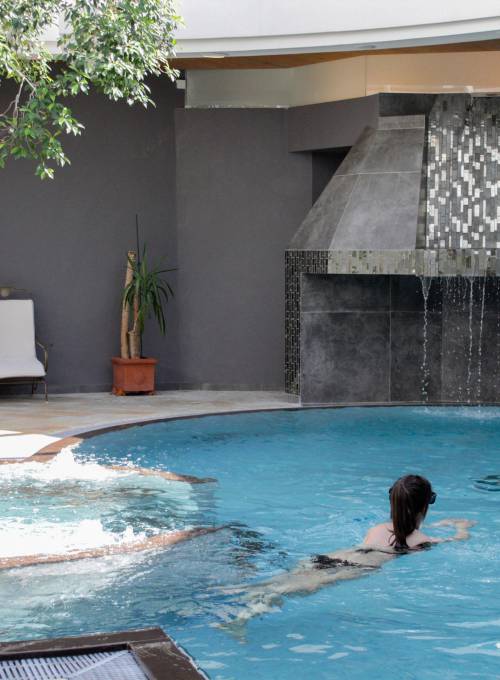 Im Sporthotel im Salzburger Land schwimmt eine Frau in unserem Pool im großen Inhouse Sport-Bereich. 