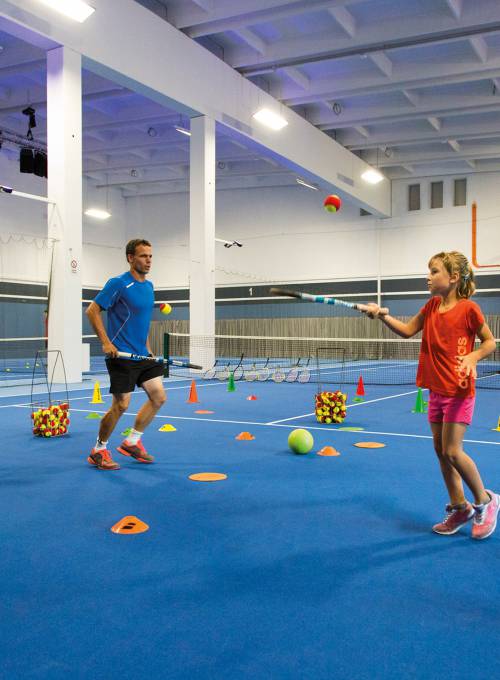 In unserem Kinderhotel in St Johann im Pongau spielt ein Vater mit seiner Tochter im Fitnessraum Tennis. 