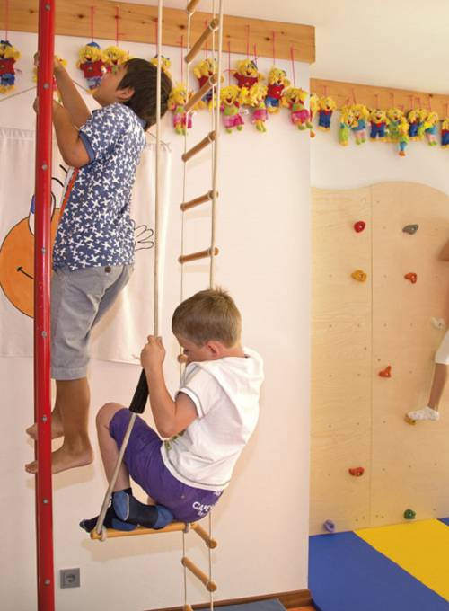 Zwei Jungs klettern im Smiley Raum in unserem Hotel mit Kinderbetreuung in Österreich. 