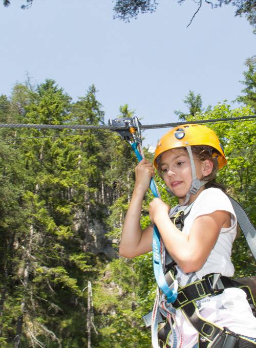 Ein Mädchen findet es aufregend, beim Flying Fox Ziplining durch das schöne Österreich zu gleiten. 