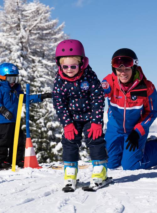 Ein kleines Mädchen lernt in der Skischule das Skifahren im Ski-Urlaub im Salzburger Land. 