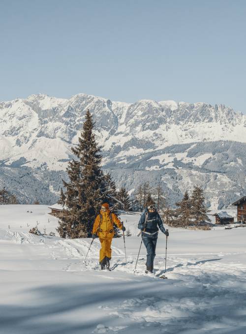 Ein Mann und eine Frau genießen die Zeit beim Langlaufski in Salzburg. 