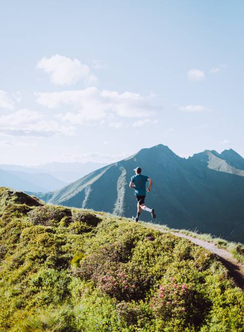 Eine Mann beim Trailrunning rund um das Sporthotel Alpina im Land Salzburg.