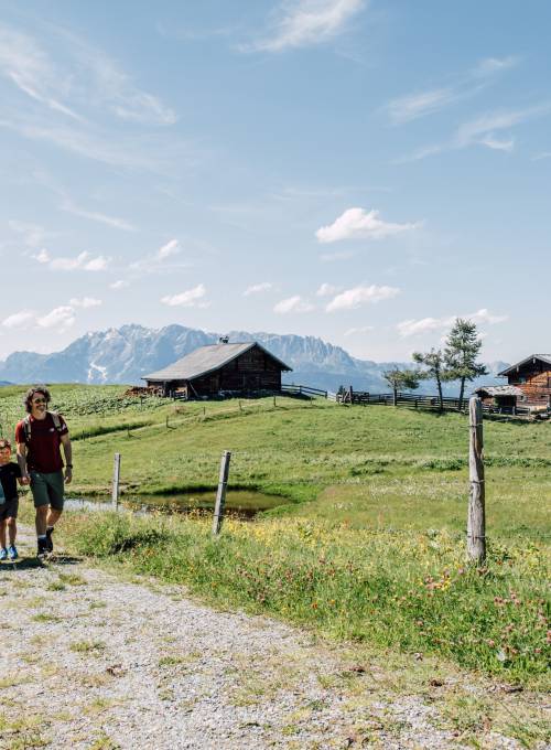 Eie Familie nutzt die geführten Wanderungen vom Hotel Alpina in St Johann bei schönem Sonnenschein. 
