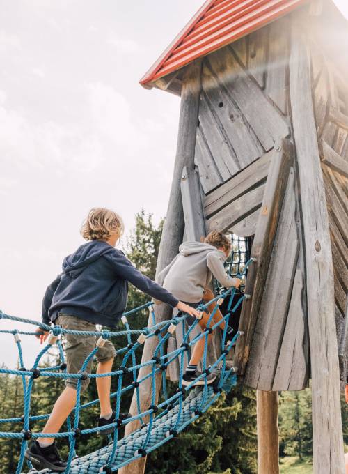 Zwei Kinder sitzen in einem Strandkorb und genießen den Familienurlaub im Salzburger Land. 