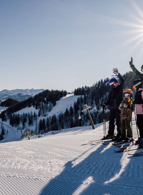 Eine Familie beim spielen im frischen Schnee in den Alpen.