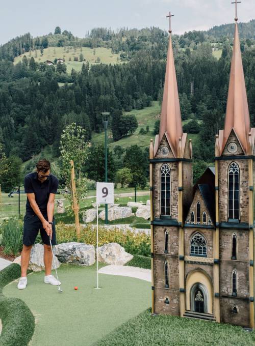 Eine Familie spielt Minigolf am OPEN Golf St.Johann.  