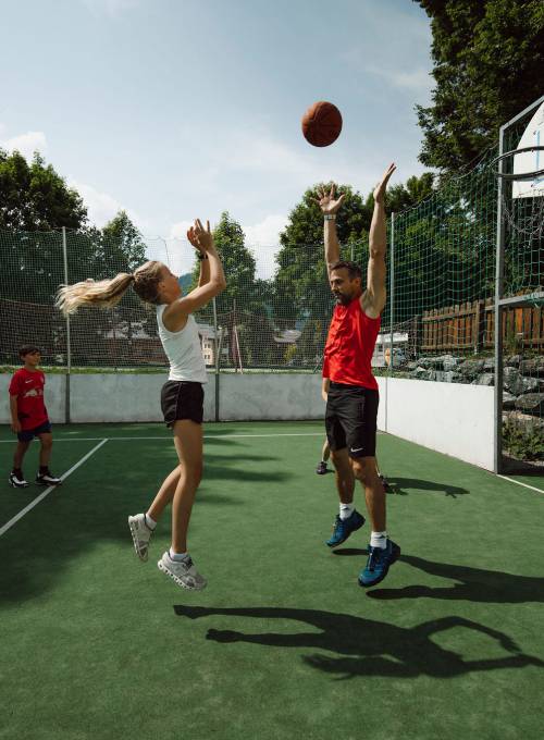 Auf dem großen Erlebnisspielplatz spielen ein paar Jungs Fußball. 