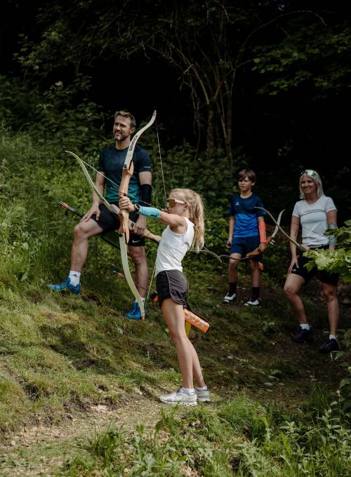 Eine Familie wandert an einem Bach in ihrem Sommerurlaub im Salzburger Land. 