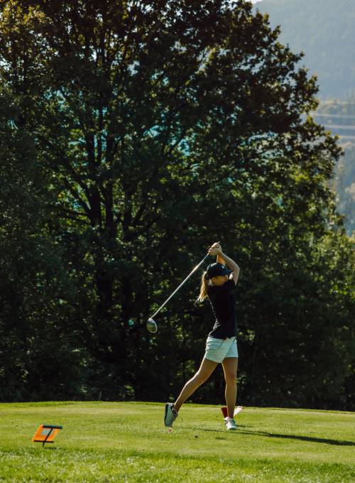 Vor einer wunderschönen Bergkulisse spielt ein Mann Golf in unserem Golfhotel in Österreich. 