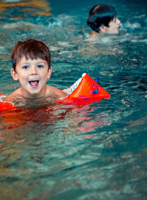 Ein Junge hat Spaß im beheizten Kinderpool während seiner Schwimmstunde im Alpina