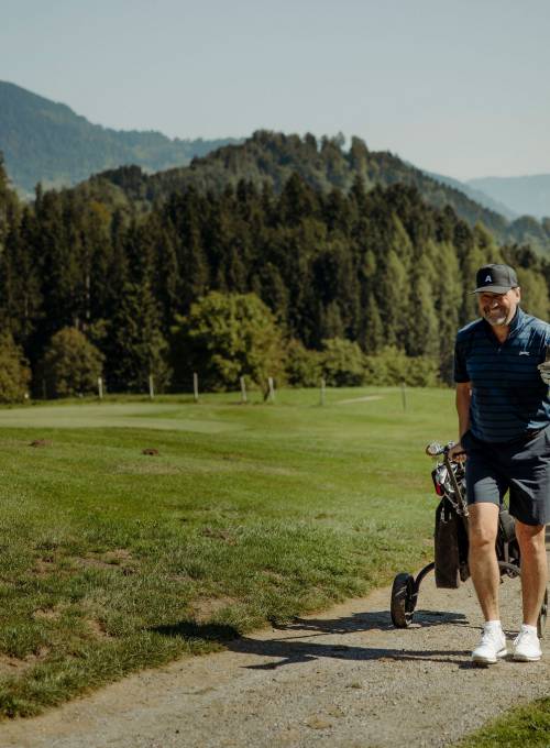 Ein Mann spielt Golf beim Golfurlaub im Alpina Alpendorf.