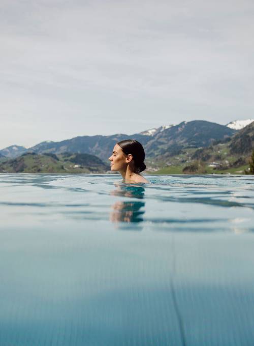 Der Ausblick auf die Berglandschaft vom Infinity-Rooftop Pool im Winter.